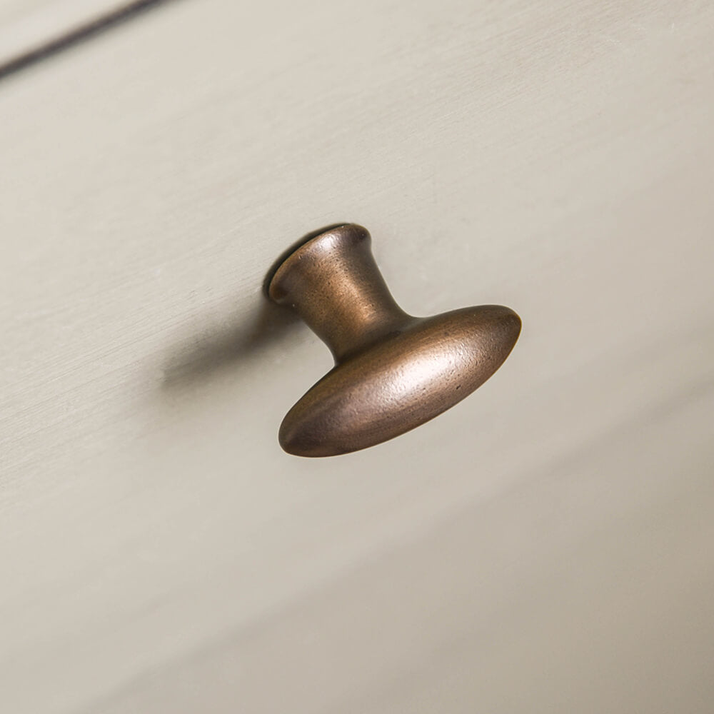Zepplin cabinet knob in distressed antique brass fitted to green kitchen drawers