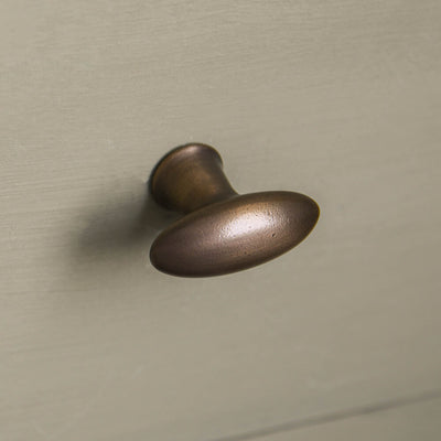 brass zepplin cupboard knob on greeny grey kitchen cabinets