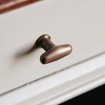 Distressed Antique Brass Elegance Cabinet Knob seen on a drawer front