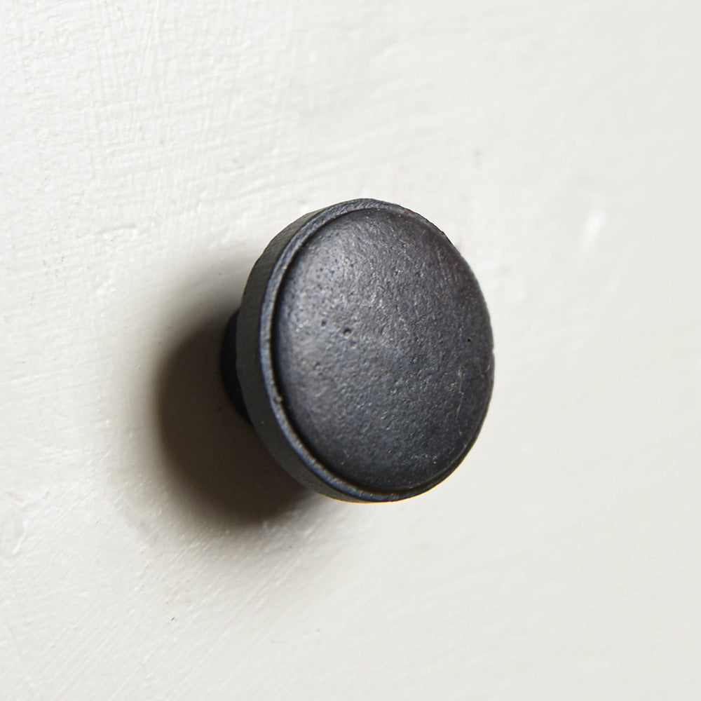 A close up photo of the cabinet knob showing the black beeswax finish