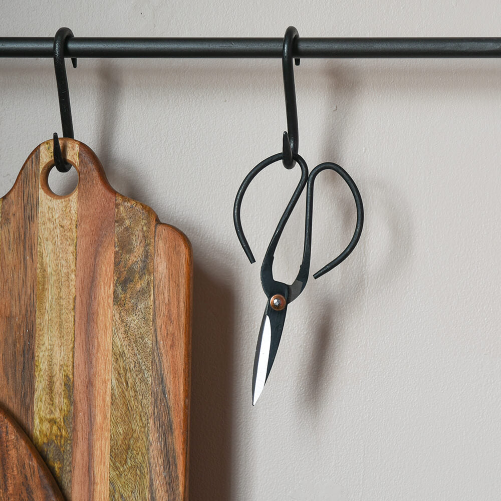 Black flower scissors handing from kitchen rail