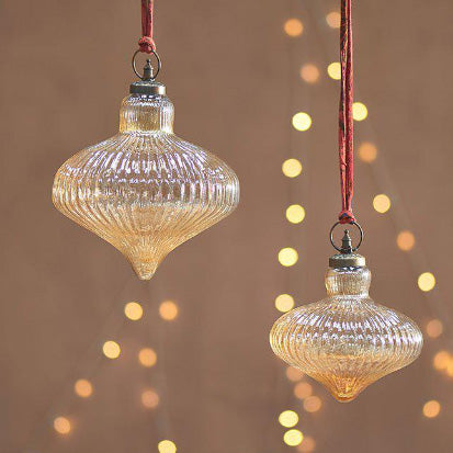 Giant Gold Lustre Baubles seen with fairy lights in the background feeling very festive 