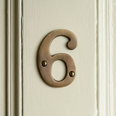 Number 6 on a front door in distressed antique brass