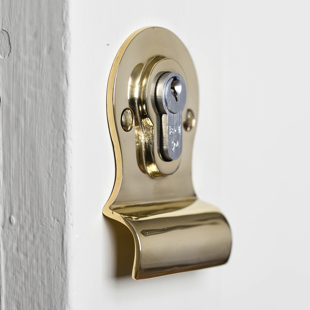 A large euro latch pull in a brass finish fitted over the euro cylinder with the door pull beneath