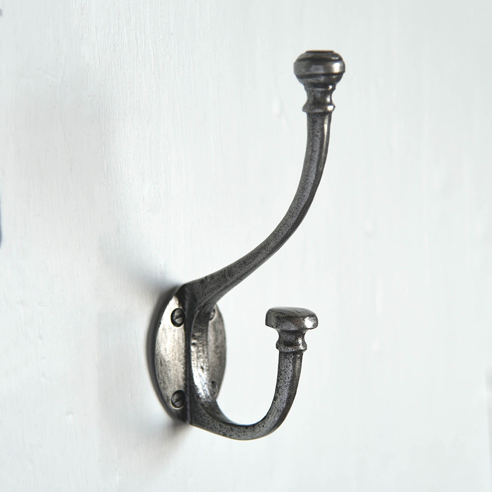 A large double coat hook in a pewter finish fitted to a wall