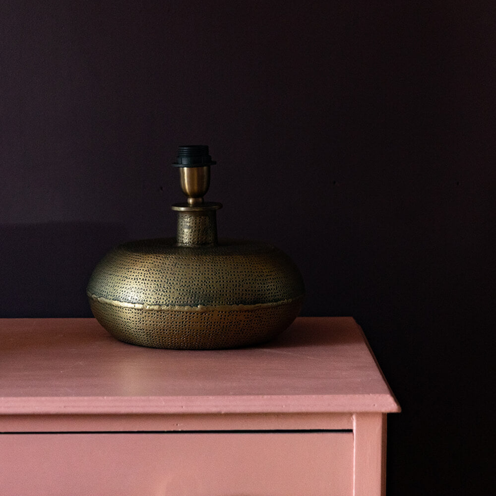 Lumbu Brass textured lamp base on pink drawers