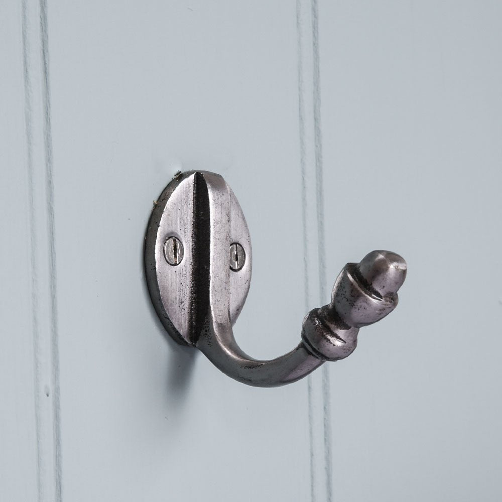 A single coat hook in natural iron finish fitted to a wall