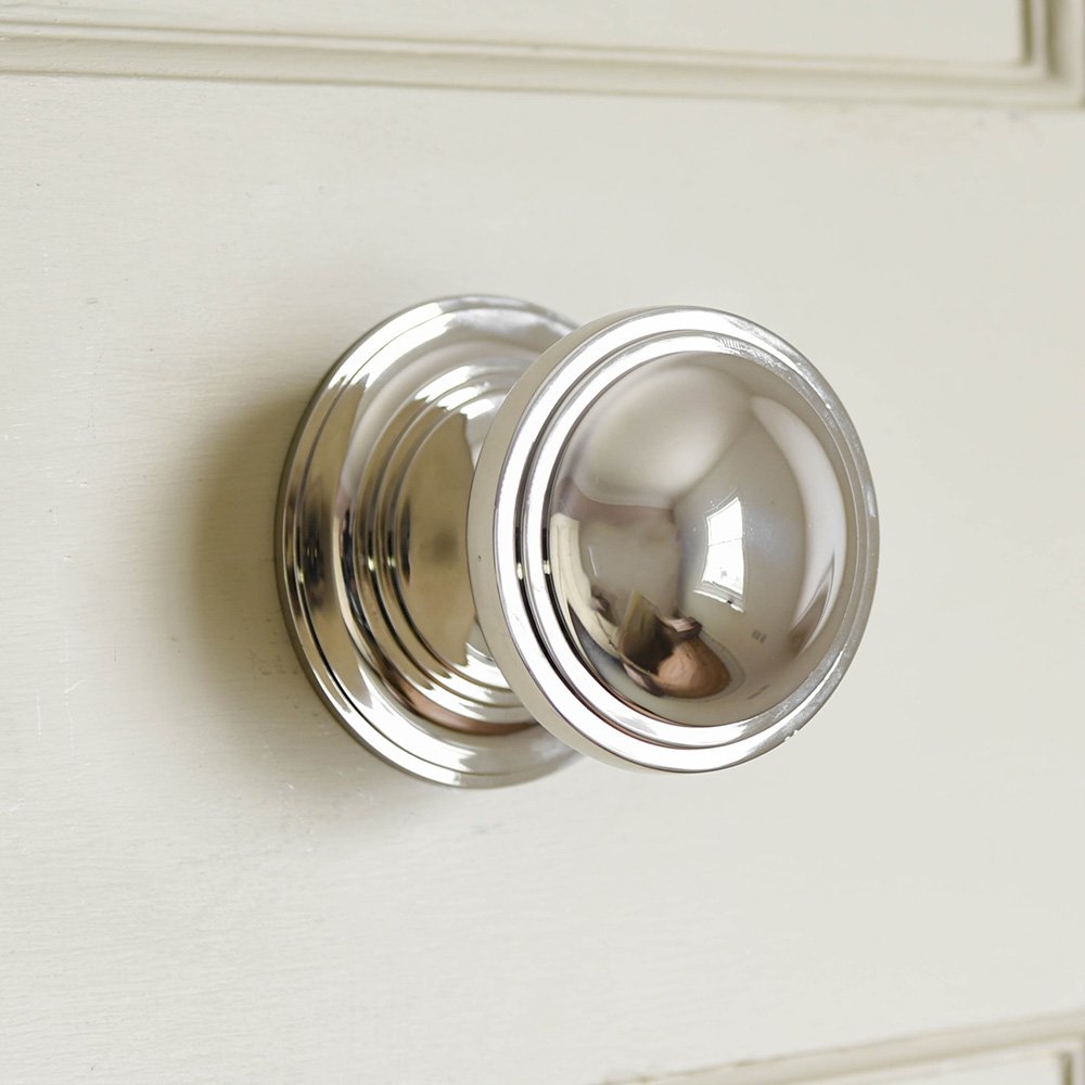 A close up photo an art deco door pull in polished nickel showing detail