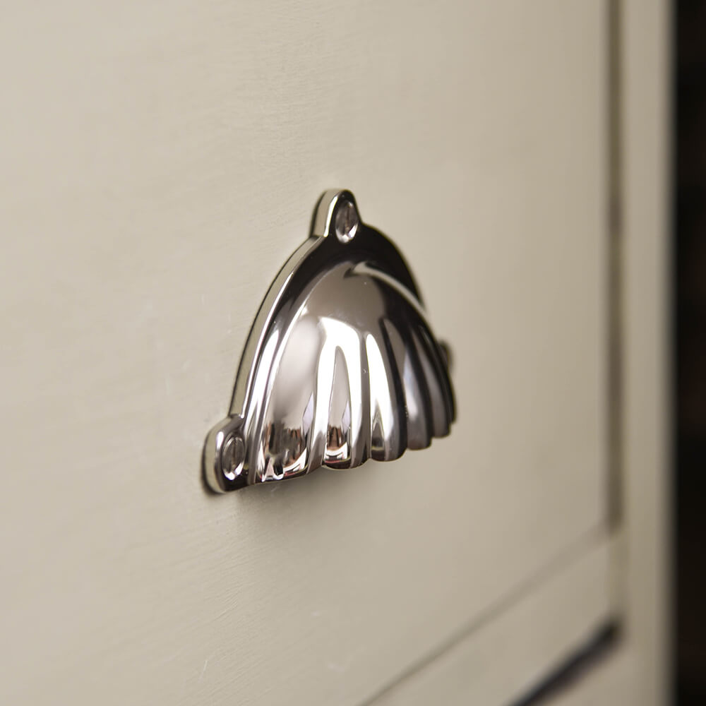 SCALLOP DRAEWR PULL SEEN IN PROFILE ON DRAWER FRONTS in polished nickel