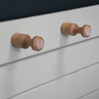 Two hang-it pegs fixed to a wooden sideboard