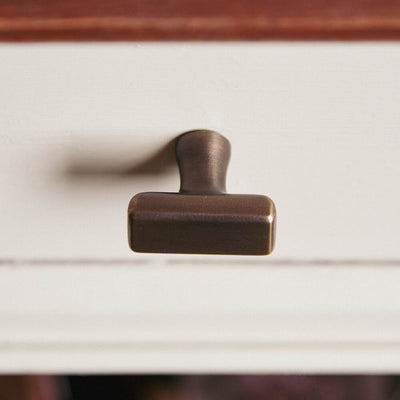 CAPITAL CABINET KNOB SEEN FROM ABOVE IN DISTRESSED ANTIQUE BRASS