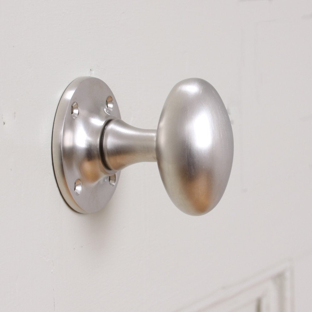 Oval shaped satin nickel door knob on round backplate