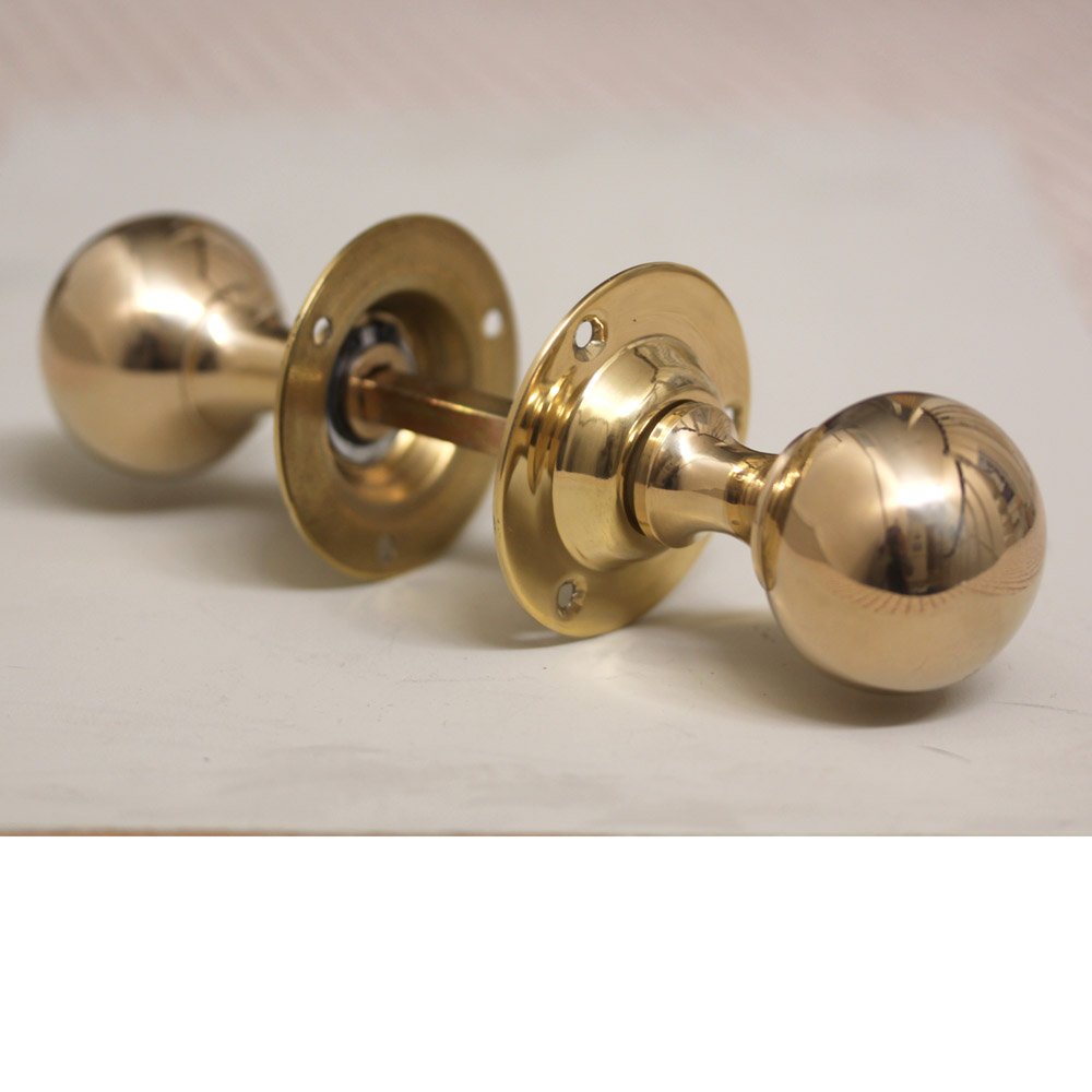 Pair of round brass door knobs with spindle