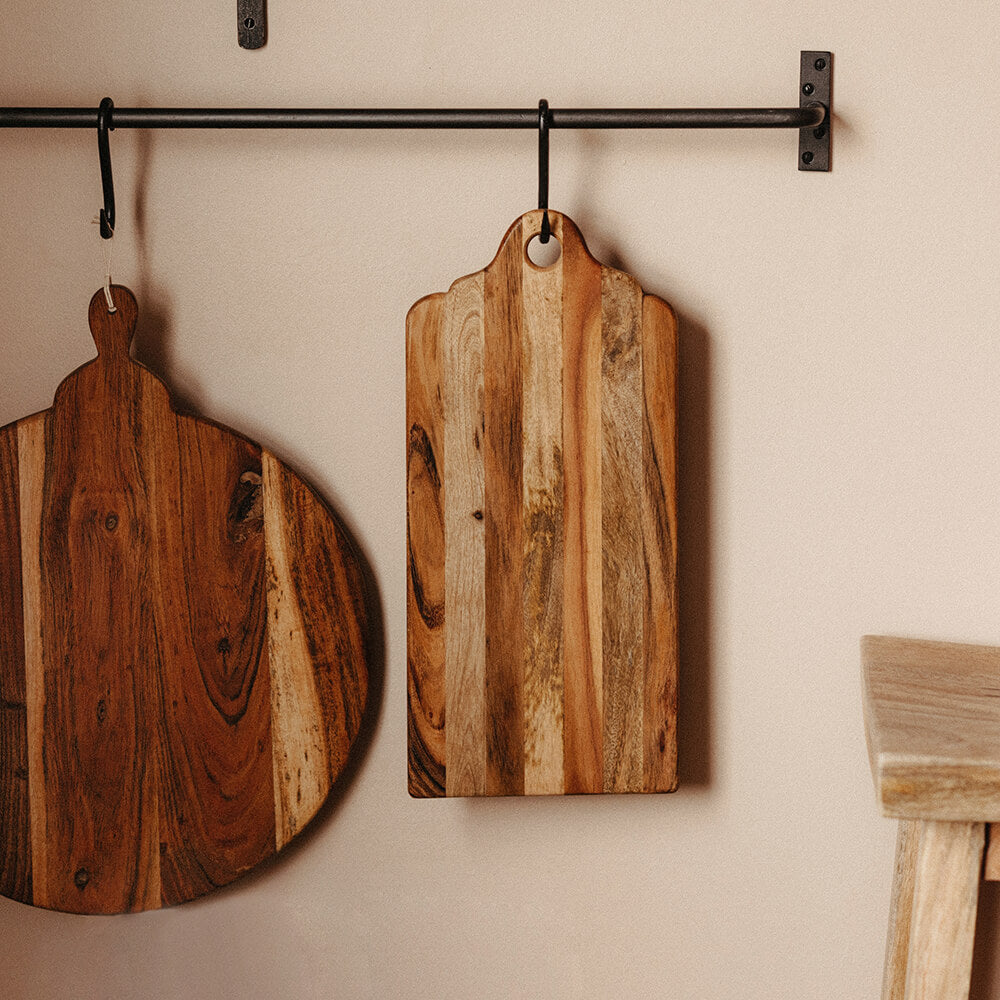 Wooden chopping board hanging from rail