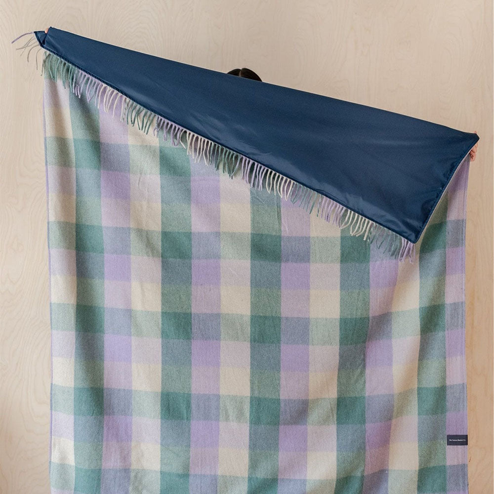 Waterproof recycled wool picnic blanket in a check pattern of lilac, green and yellow