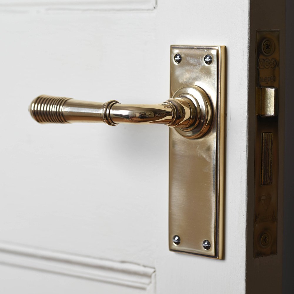 A Reeded Lever Handle with a plain backplate in an aged brass finish