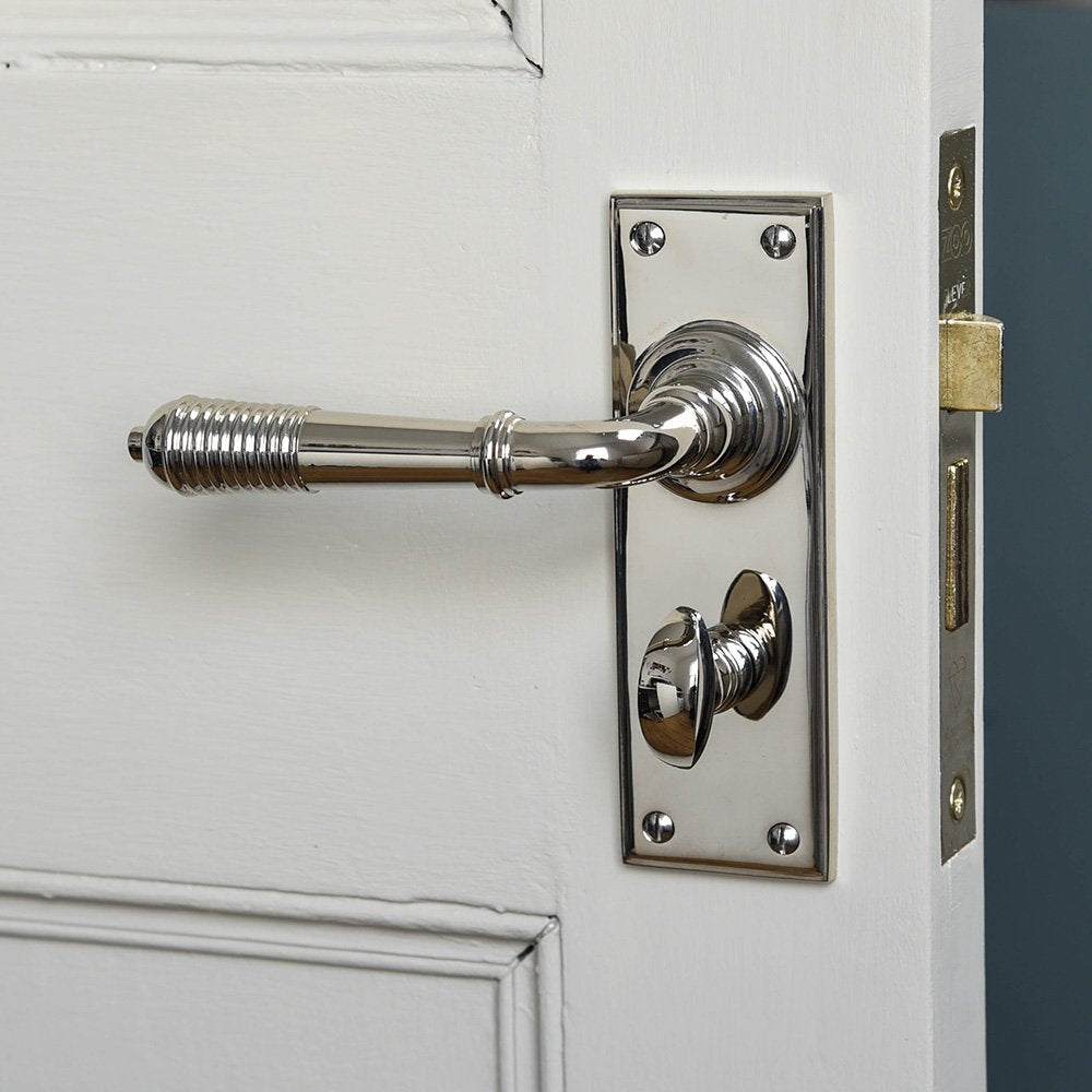 A Reeded Lever Handle with Bathroom Lock  fitted to a door
