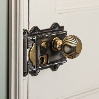 Regency style cast iron rim latch with brass beehive door knob