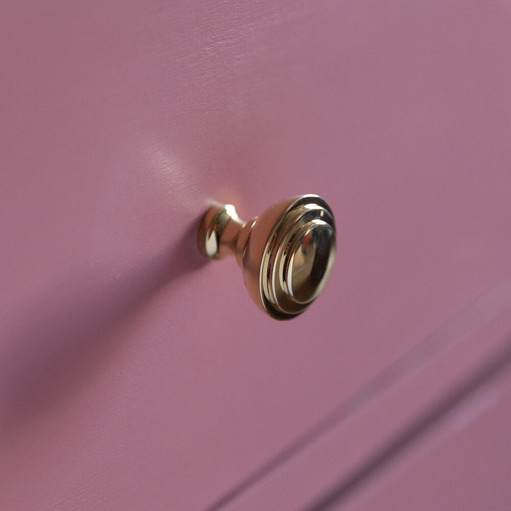 Ribbed Brass Cabinet Knobs seen on pink chest of drawers