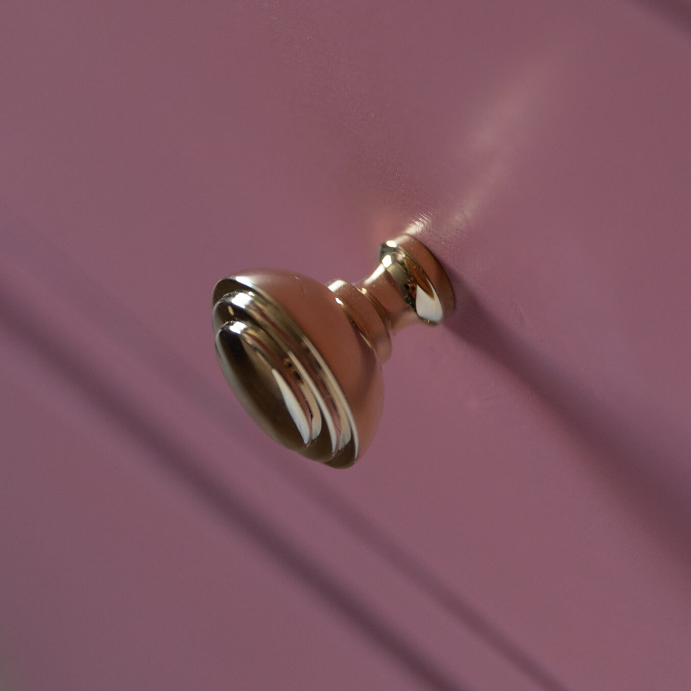 Ribbed Brass Cabinet Knobs seen on pink chest of drawers detail