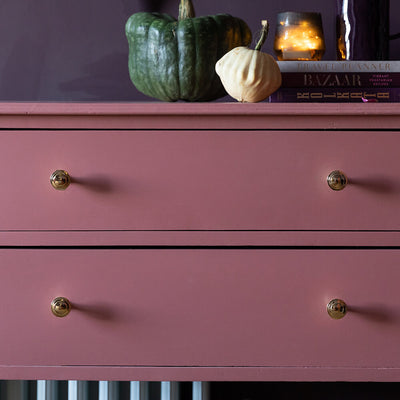 Ribbed Brass Cabinet Knobs seen on pink chest of drawers with accessories