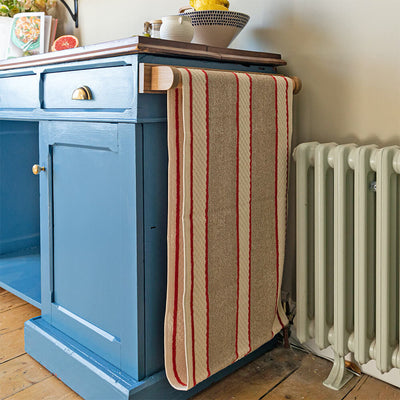 Oak roller towel with red towel on blue dresser