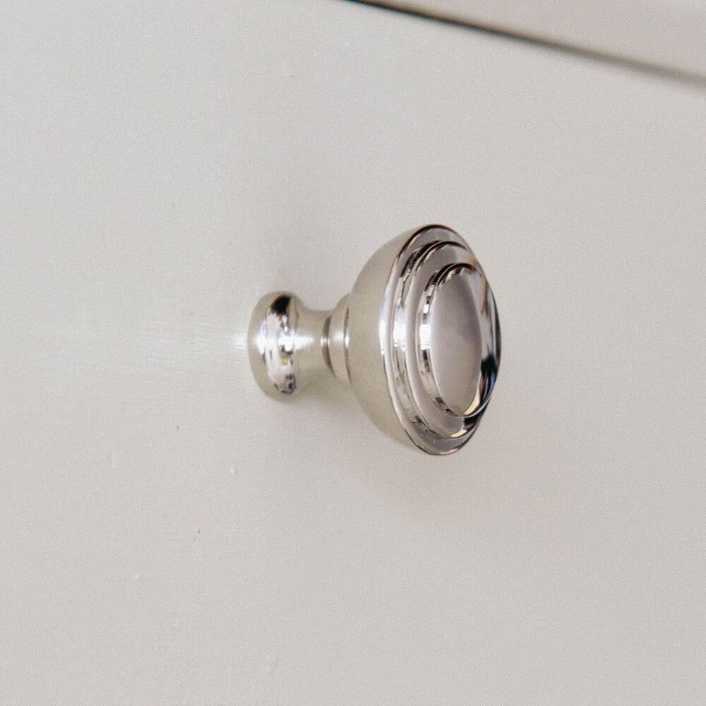 Nickel cupboard knob with two reeded circles to the top on a set of drawers