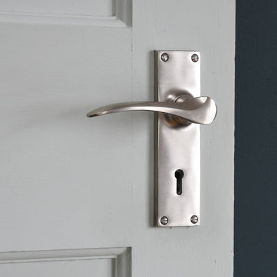 Satin nickel door handle with rectangular backplate with a keyhole