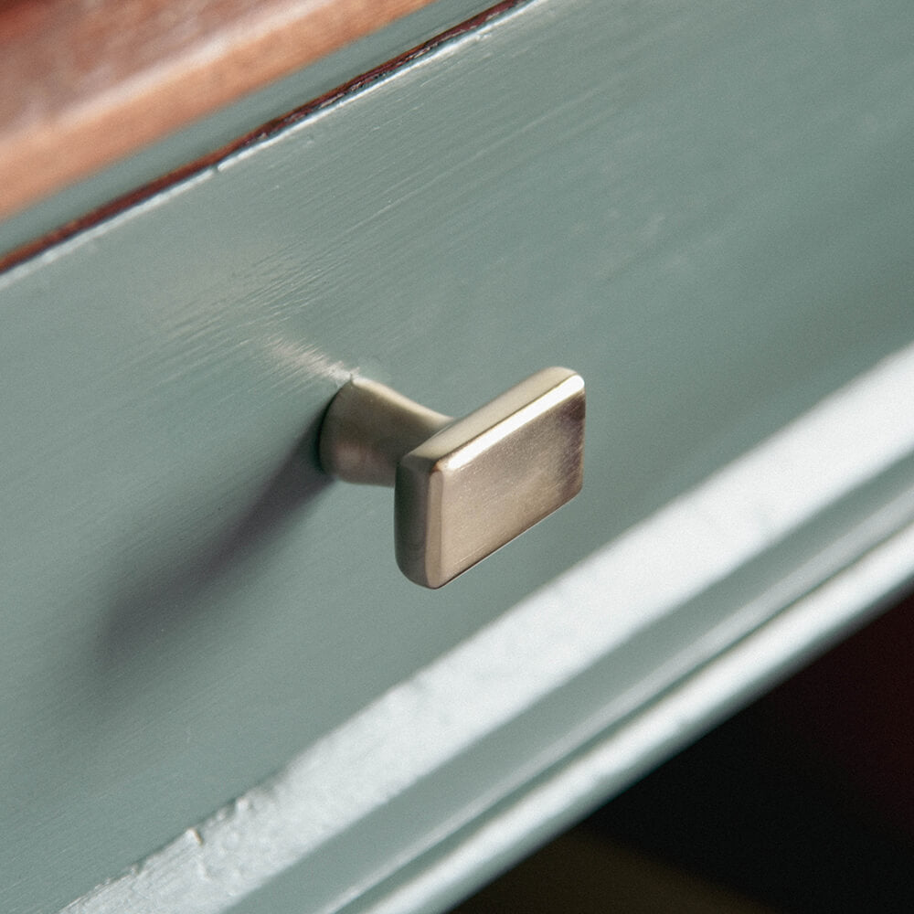Satin Nickel Capital Cabinet knob on blue kitchen drawer
