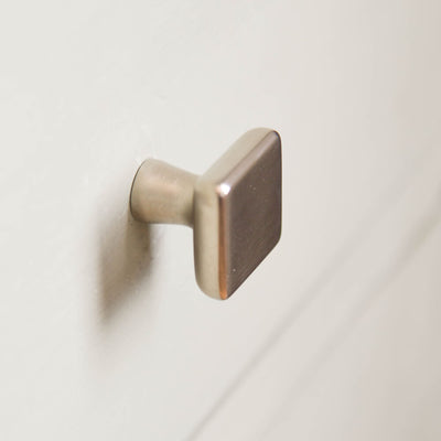 Plaza cabinet knob on blue drawers seen from the side, solid brass plated in satin nickel