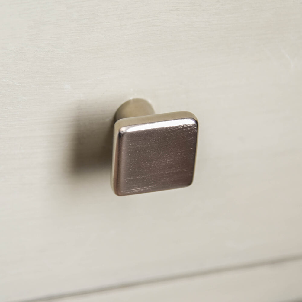Satin Nickel Cabinet Knob on kitchen cupboard, square knob with a tapered neck, seen from the front.