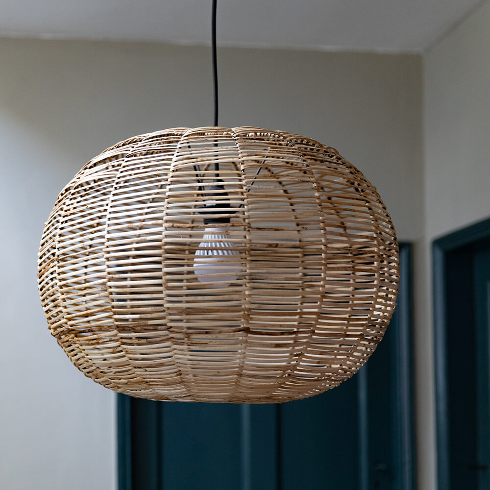 wicker oval pendant light with painted doors behind