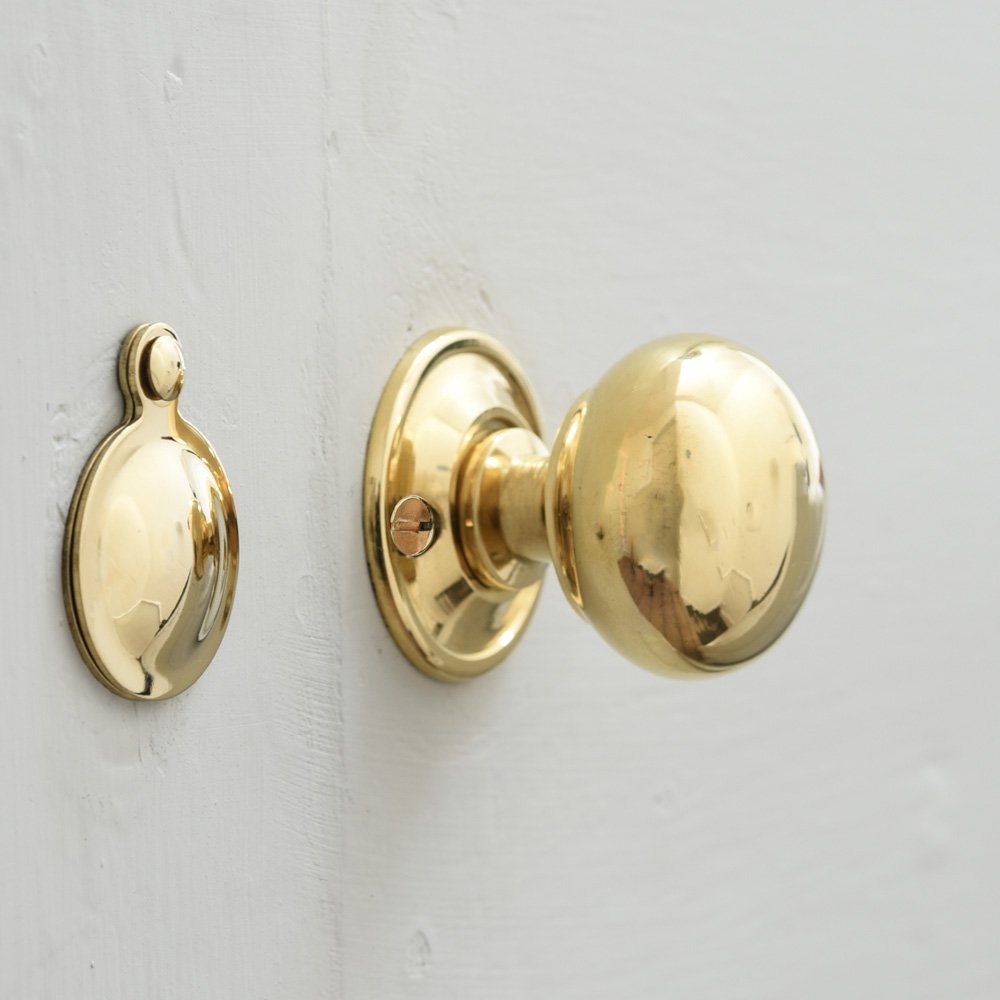 Small brass cottage bun door knob with escutcheon