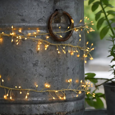 led silver claster fairy lights wrapped around a galvanised planter outdoors