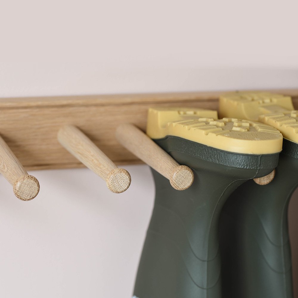 a close up photo showing the oak pegs holding wellingtons upside-down