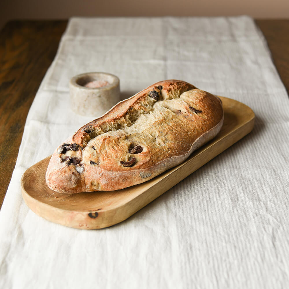 Wooden bread board platter with olive bread