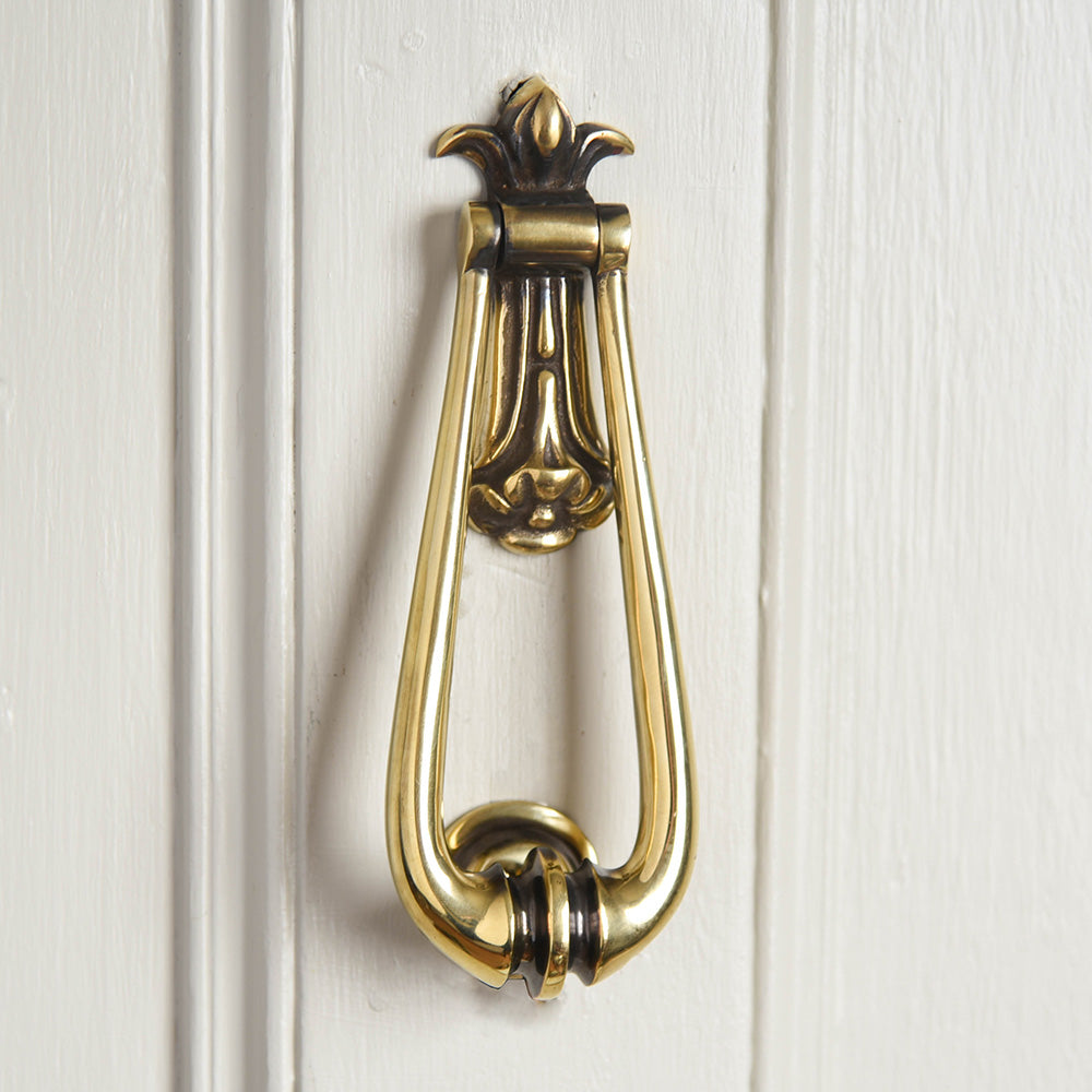 Aged Brass Loop Door Knocker Hung On A Front Door