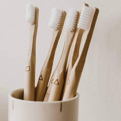 neutral toned bamboo toothbrushes sat in holder