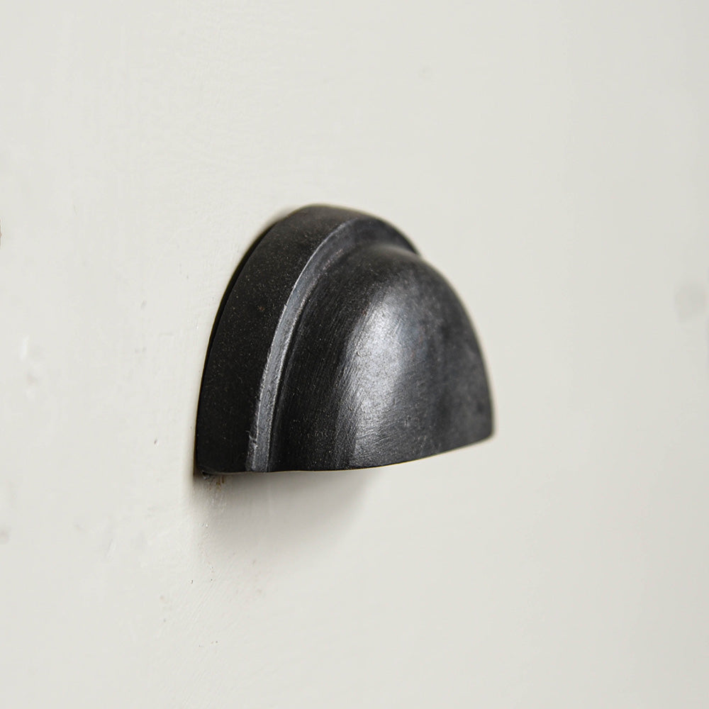 A side profile of the concealed drawer pull in black beeswax