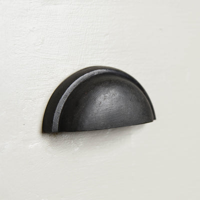 Regency concealed drawer pull in a black beeswax finish fitted to a drawer