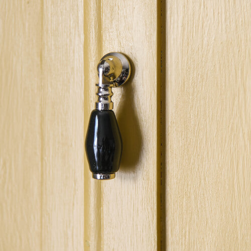 Nickel and black ceramic drop pull on yellow cupboard door