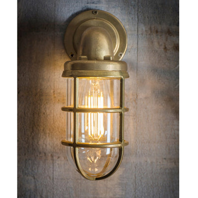 Head-on view of brass downlight in naval style with cage around glass shade