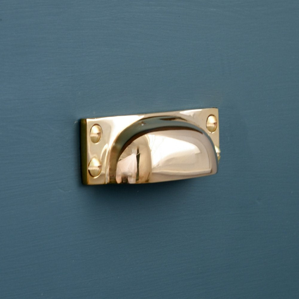 Close up of Slim Brass Hooded Drawer Pull on teal drawer.