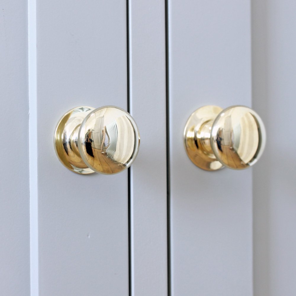 Two brass cabinet knobs on cupboard doors