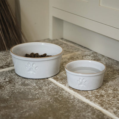 Large (left) and small (right) white ceramic pet bowls with single paw print design