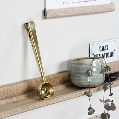 Coffee scoop with brass finish on picture ledge