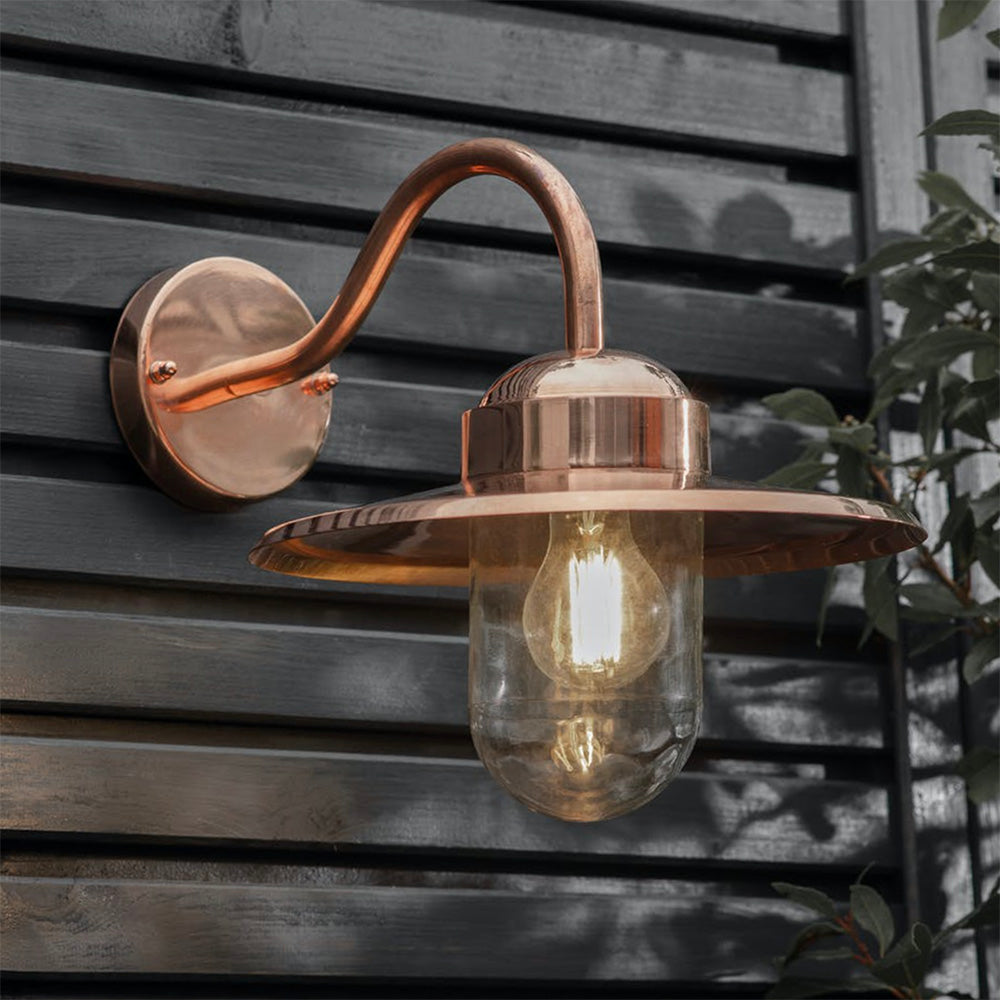 Raw copper wall light with clear glass shade