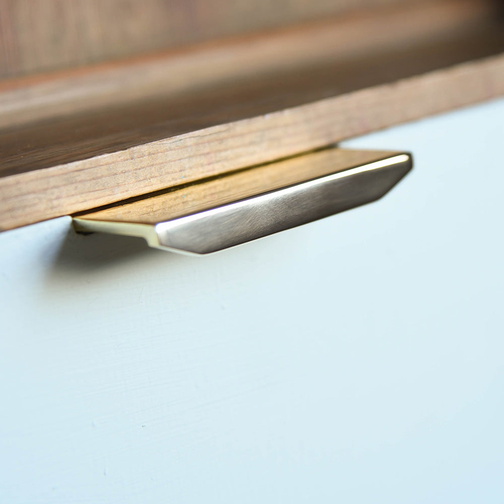 Tapered Cabinet Edge Pull in Polished Brass on cupboard drawer.