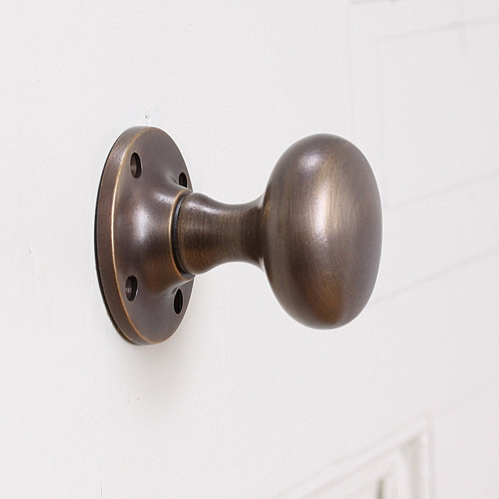 Cushion Door Knobs in Distressed Antique Brass from Side