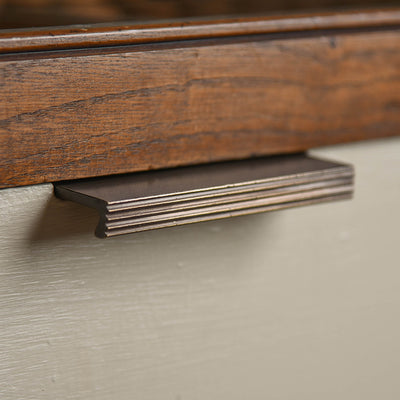 Solid brass Reeded Cabinet Edge Pull in Distressed Antique finish on drawers.